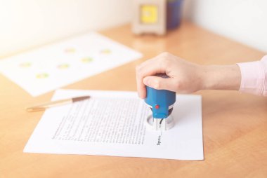 Kadının elini kapat ve sözleşmeyi imzalarken ve imzalarken mavi pulu tut, yatırım yap, sigorta al, yazma belgesi al, imzala, damgala, pankart