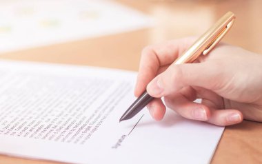 İş kadını, ofis masasında dosyalar, damga ve kontrat imzalıyor, kapanış anlaşması imzalıyor.