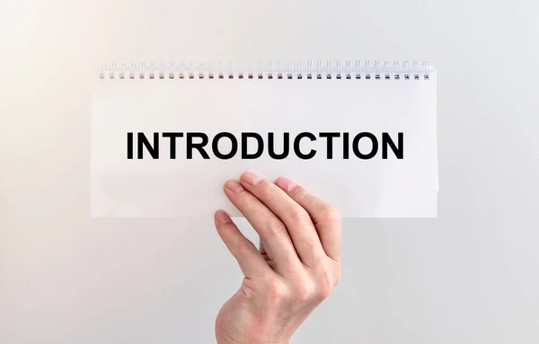 Introduction. word Text on a sheet of paper. hand of businessman, business introduction concept