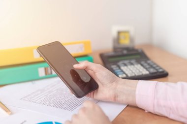 Kablosuz bağlantı kurarken kadın ellerini kapat. İşadamı teknolojisini kullanarak ahşap masada oturuyor. Her yerde insanlar ve modern cihazlar var.