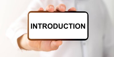 Beyaz kağıda yazılan kelime, beyaz arka planda erkek eli ile yapılan telefon ekranı.