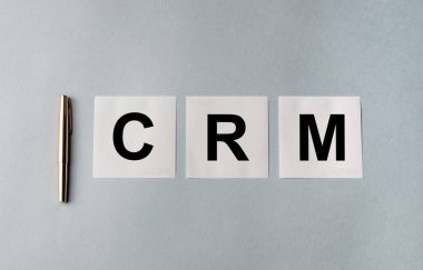 CRM metin kısaltması - Müşteri ilişkileri yönetimi - mavi ofis masasındaki beyaz yapışkan notlar, üst görünüm, iş konsepti