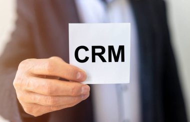CRM metin kısaltması - Müşteri İlişkileri Yönetimi - iş adamının ellerinde.