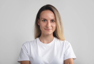 Genç, güzel Avrupalı ya da Amerikan kadınlarına hafif bir gülümseme. Günlük kıyafetlerle kameraya bakıyor. Yaklaş.