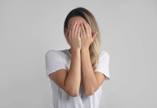 Junge Europäerin Weißen Shirt Verbirgt Ihr Gesicht Mit Beiden Handflächen — Stockfoto