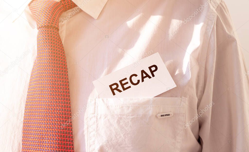 RECAP word inscription on paper card in pocket of male white shirt with red tie, close up.