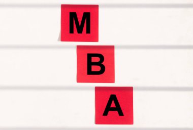 İş eğitimi konsepti. Beyaz ofis masasında MBA kısaltması olan kırmızı çıkartmalar ya da çizgili duvar, işletme yönetimi ustası.