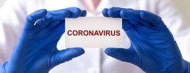 Koronavirüs kavramı. 2019-nCoV yazıtları beyaz kağıda yazılmıştı. Doktorların elinde koruyucu eldivenlerle. Pankart