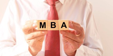 İş eğitimi konsepti. İşadamlarının elindeki tahta küplere MBA kısaltması yaz..