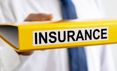İşadamının elindeki sarı klasörle ilgili INSURANCE kelimesi.