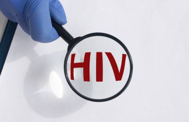 HlV yazıtlı metin kısaltmalı büyüteç - insan bağışıklık yetmezliği virüsü - doktor eliyle eldivende.
