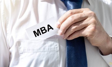 İş eğitimi konsepti. Beyaz kağıt üzerinde MBA kısaltması beyaz gömlekli iş adamı cebinde, kravatı yakın.