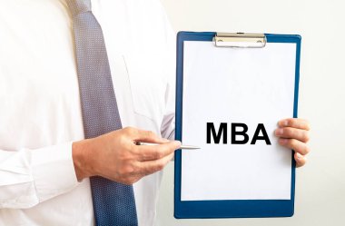 İş eğitimi konsepti. Beyaz kağıt üzerinde MBA kısaltması beyaz duvar üzerinde iş adamı elleri.