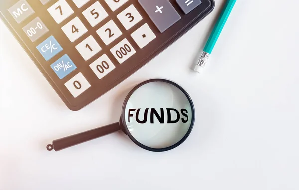 Funds Word Μέσω Μεγεθυντικό Φακό Λευκό Τραπέζι Αριθμομηχανή Έσοδα Έξοδα — Φωτογραφία Αρχείου