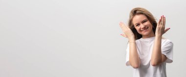 Mutlu, gülümseyen, beyaz arka planda elini kusan, sarışın, beyaz bir kadın. Stüdyo çekimi. kopyalama alanı, afiş