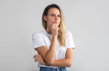 Şüpheli bir kadının çenesine bakıp, gri arka planlı Stusio Potrait....