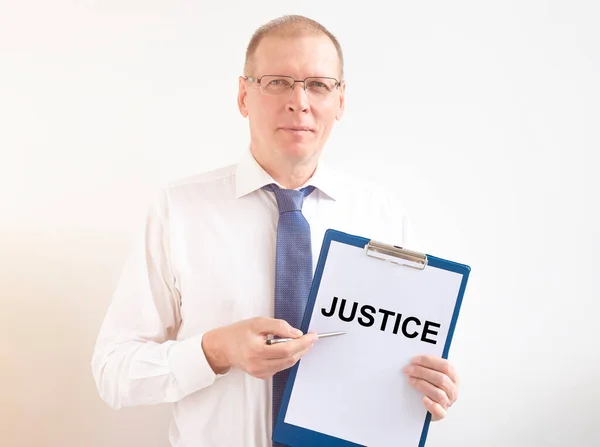 正义一词写在白纸上 由律师手握衬衫和领带 — 图库照片