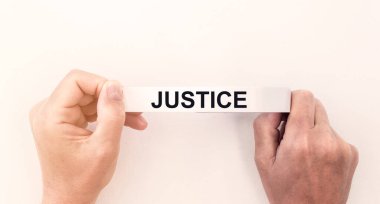 Adalet sözcüğü beyaz bantla yazılmış erkeklerin ellerinde.