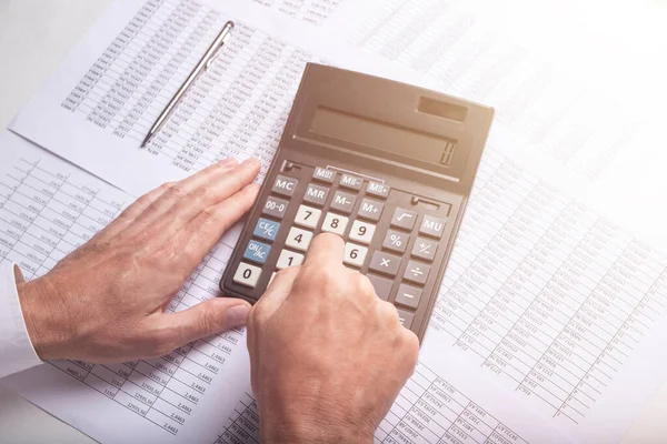 Financial analysis concept, male hands using a calculator over accounting documents, closeup, top view — Stock Photo, Image
