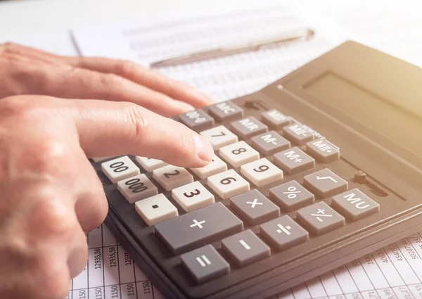 Financial analysis concept, male hands using a calculator over accounting documents, closeup — Stock Photo, Image