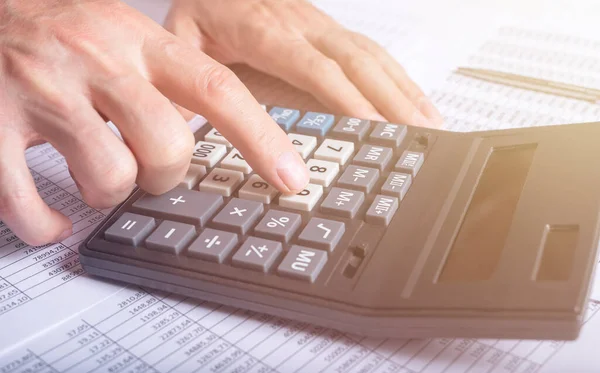 Concetto di analisi finanziaria, mani maschili utilizzando una calcolatrice su documenti contabili, primo piano — Foto Stock