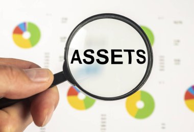 Ofis masasındaki büyüteçle kağıt üzerinde kelime hazineleri. Finansal muhasebe. Para kavramı