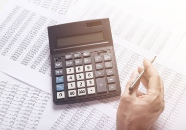 Finansal analiz kavramı, muhasebe belgeleri üzerinde hesap makinesi kullanan erkek eli kalem..