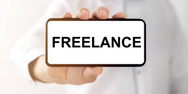 Kelime FREELANCE telefon ekranında erkek elinde, telefon kavramından uzak iş