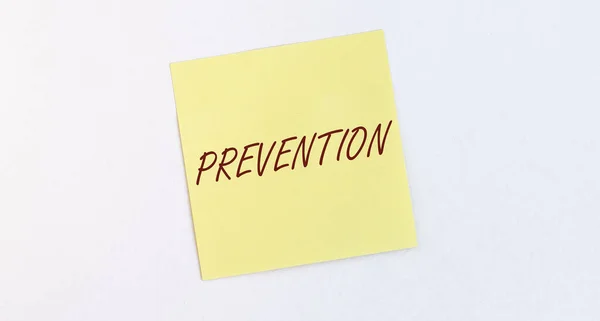 Palavra Prevenção Nota Papel Amarelo Parede Branca — Fotografia de Stock