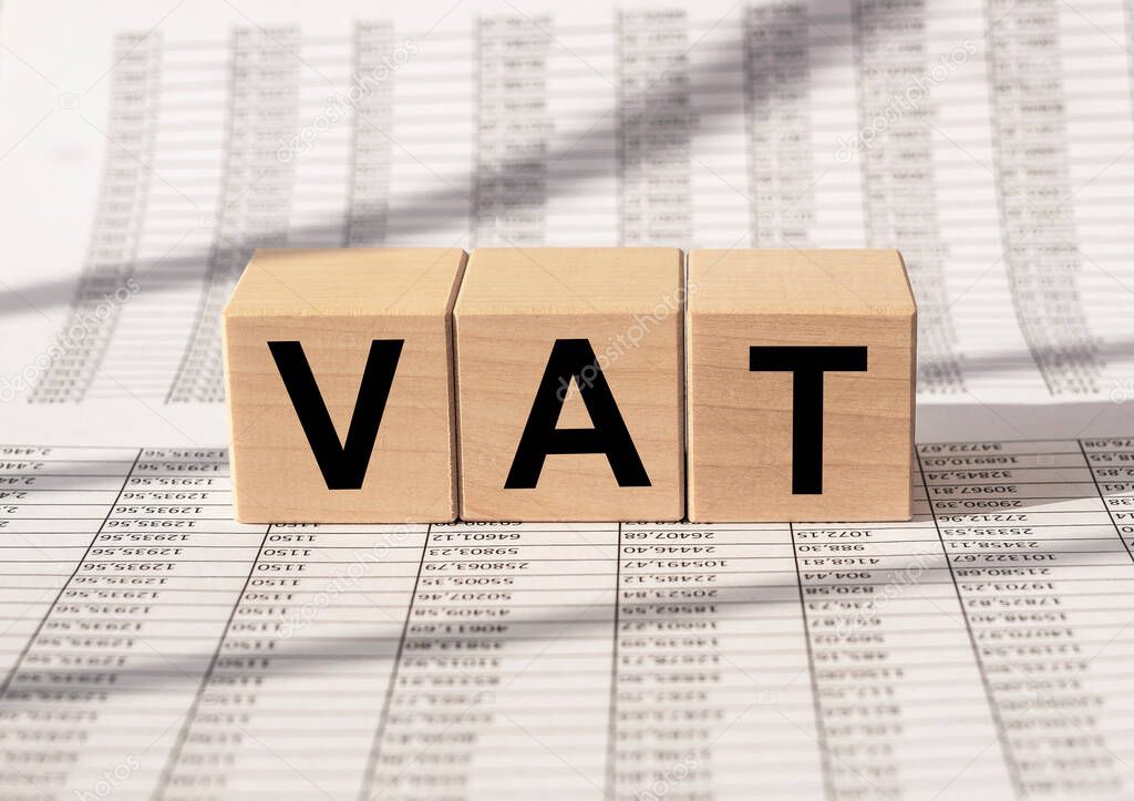 VAT text, Value Added Tax, inscription on cube blocks on financial background.