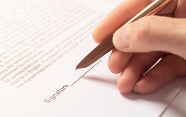 Sözleşme imzalama konsepti. Belgeyi yakın plan üzerine yazan iş adamı eli.