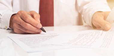 Sözleşme imzalama konsepti. İşadamı elinde kalemle belgeyi kapatıyor. Pankart