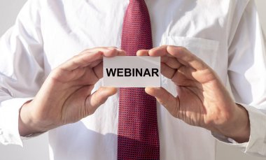 Kağıt üzerinde kelime Webinar iş adamlarının elinde.