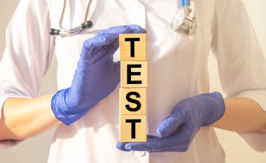 Tahta küp blokları üzerinde kelime testi doktorların elinde mavi koruyucu eldivenler, virüs konsepti.
