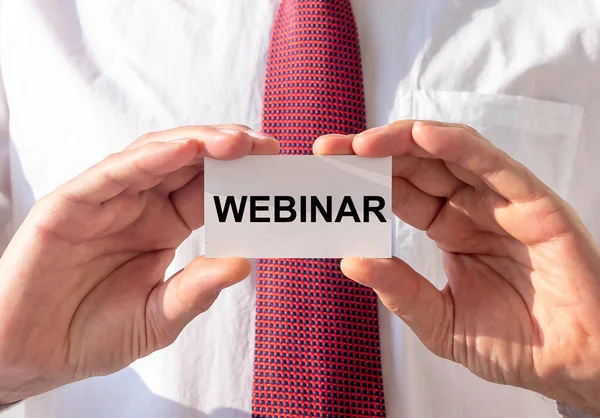 Kağıt üzerinde kelime Webinar iş adamlarının elinde.