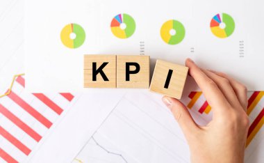 KPI, Kadınlardaki küp blokları üzerindeki Anahtar Performans Göstergesi metni analitik belgeleri renkli diyagramlarla birlikte teslim et