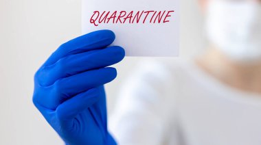 Sözcük QuaranTINE kağıt üzerinde bulanık ellerinde mavi koruyucu eldivenler, pankart