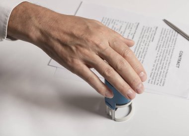 Beyaz erkek beyaz el damgası ya da mühürleme belgeleri beyaz ofis masasının üzerine kapanış sözleşmesi, üst görünüm