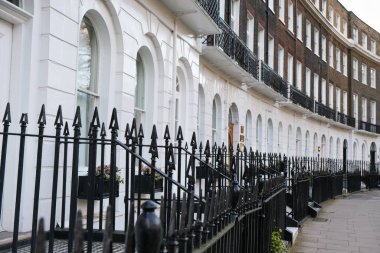 Bir sıra teraslı Gürcü tarzı konak, önlerinde parmaklıklar ve önlerinde bir patika var, Londra 'da..