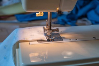 Dikiş makinesinin iğnesine yakın çekim. Dikiş malzemesi. Ev yapımı yüz maskesi yapmak için.