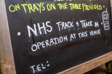 Bir barda el yazısıyla NHS ile ilgili bir tabela. Barlar ve restoranlar yeniden açılmaya başlarken İngiltere 'de kapanma kolaylaşır.
