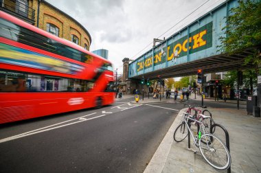 30 EPTEMBER 2019: Camden High Caddesi 'nin karşısındaki demiryolu köprüsünde bulunan meşhur Camden Lock tabelasının bulanık bir Londra çift katlı otobüsü yaklaşıyor.