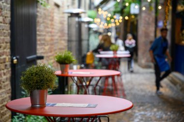 30 Eylül 2019 'da Camden Market' in açık hava yemek alanındaki kaldırımlı bir caddede bir sıra boş masa ve arka planda insanlar vardı.