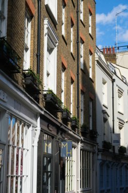Londra, İngiltere - 1 Mart 2020: Güneşli tuğla dükkânı boyunca Londra, İngiltere 'de bir sokakta gölgeli bir manzara.