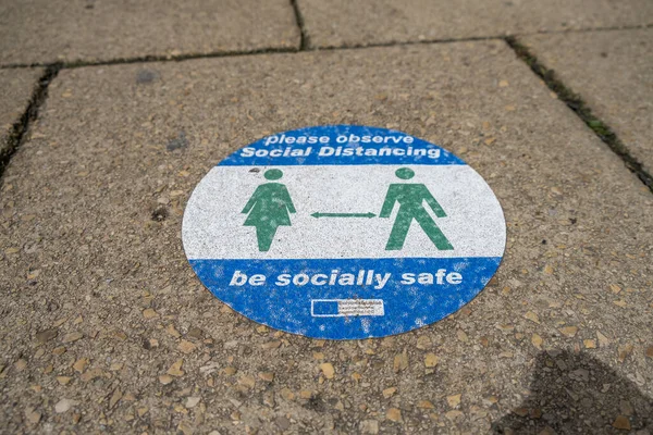 Richmond, Kuzey Yorkshire, İngiltere - 1 Ağustos 2020: Richmond şehir merkezindeki bir katta insanların covid 19 'un yayılmasını önlemek için sosyal mesafeyi korumasını isteyen bir etiket