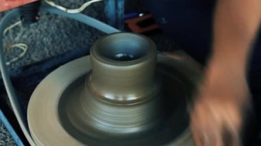 Parmaklı adam çömlekçide kil kasesinin altını hazırlıyor. El yapımı, el işi ve yaratıcı sanatlar..
