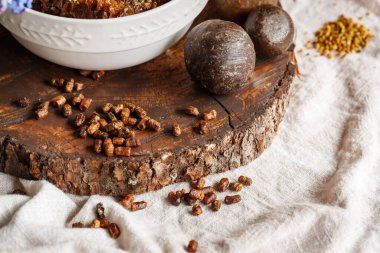 Arı ürünlerini kapatın sarı turuncu sağlıklı polen perga parşömeni arılar tarafından koyu kahverengi ahşap kesim ve keten kumaş masa örtüleri propolden yapılmıştır.