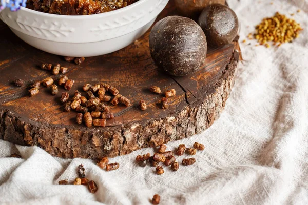 Arı ürünlerini kapatın sarı turuncu sağlıklı polen perga parşömeni arılar tarafından koyu kahverengi ahşap kesim ve keten kumaş masa örtüleri propolden yapılmıştır.