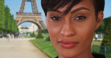 Karışık yarış genç bayan kamera Paris Eiffel Tower yakınındaki bakarak tatil