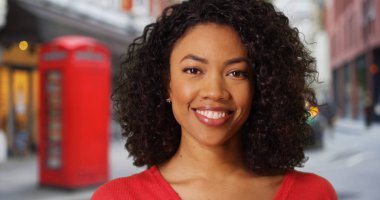 Mutlu genç Afrikalı kadın kameraya sokak süredir Londra İngiltere'de gülümseyerek.